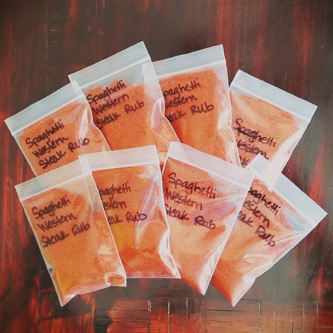 Small resealable bags filled with reddish-orange Spaghetti Western Steak Rub hand-labeled in black ink.