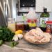 Ingredients for Cajun Chicken marinade arranged on a kitchen counter, including garlic, lemons, parsley, smoked paprika, soy sauce, Worcestershire sauce, oil, and red pepper.