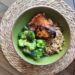 Grilled Chinese chicken thigh served with broccoli and wild rice pilaf in a green bowl.