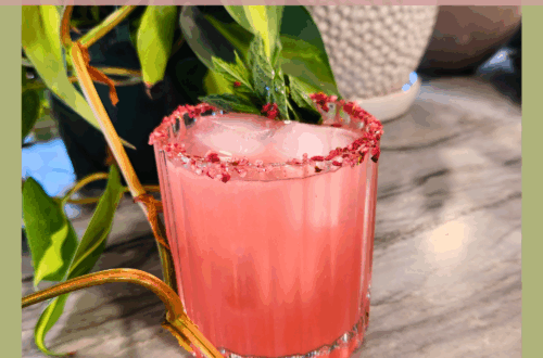 Pinterest graphic featuring a pink Witchlight Fizz mocktail in a faceted glass, rimmed with raspberry citrus salt and garnished with mint. Surrounded by trailing houseplants, with text overlay: Witchlight Fizz Mocktail – for Stargazers & Dreamers.
