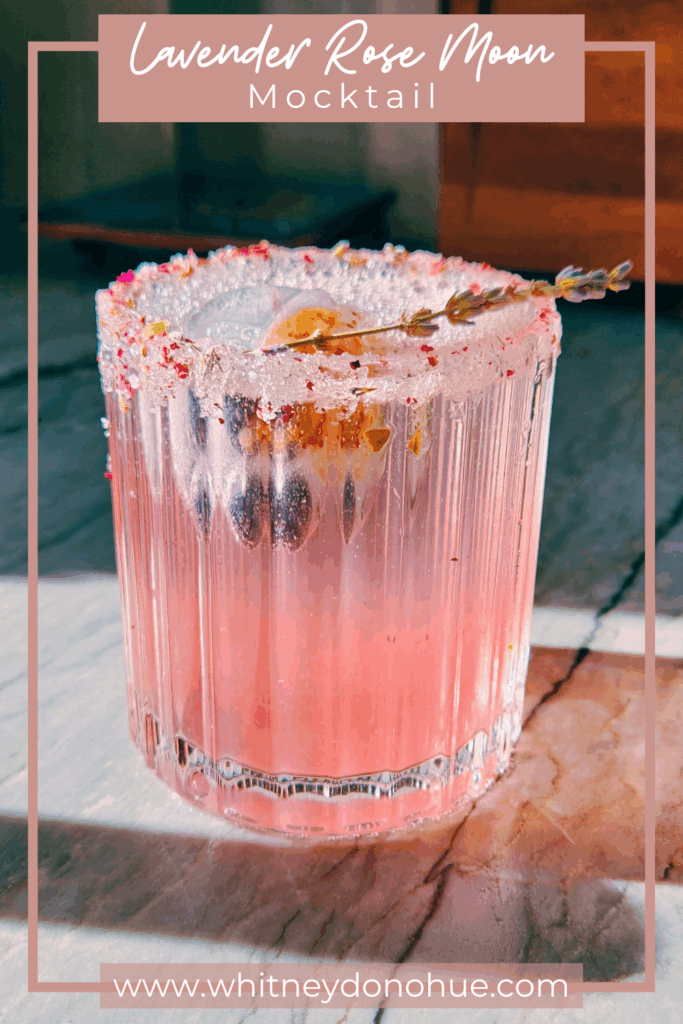 Lavender Rose Moon Mocktail with text overlay, featuring a pink floral drink in a sugared petal-rimmed glass, garnished with a lavender sprig and glowing in natural light.